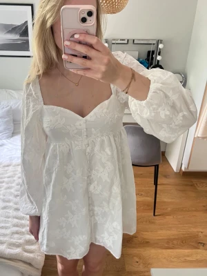 Vit sommar klänning  - Supersöt vit klänning från Gina Tricot med blommigt mönster. Aldrig använd, säljer pga hittat annan klänning till studenten. Passar perfekt till student och sommar tillfällen! 