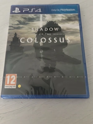 Shadow of the Colossus till PS4 - Shadow of the Colossus till PlayStation 4 är ett actionäventyrsspel med episka bossfighter och storslagen grafik. Spelet kommer i ett blått plastfodral med omslag i mörka färger och fantasytema. Perfekt för dig som gillar äventyr och utmaningar.