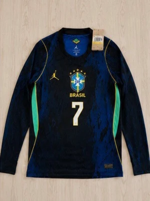 Brasilien långärmad matchtröja Vini Jr. - Snygg långärmad Brasilien-tröja från Jordan med nummer 7 och Vini Jr. på ryggen. Tröjan är mörkblå med gröna och gula detaljer, Brasilien-emblem på bröstet och Jordan-logga. Perfekt för fotbollsträning eller att bära som supporter.