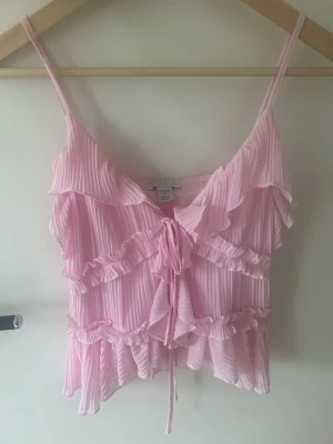 Rosa volang topp - säljer en super söt och somrig rosa volang topp men knyt i mitten, den är i storlek S och i jättebra skick!💗💗