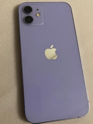 Lila iPhone 12 med dubbla kameror - Skärmen är sprucken och trasig, och Razers framkamera är trasig. Den har 128 GB lagringsutrymme, men enheten fungerar normalt.
