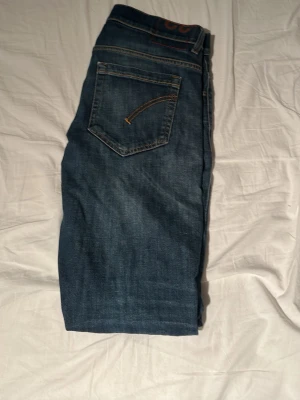 Blå raka jeans med slitning - Säljer ett par blå jeans med rak passform och slitning på vänster knä. Jeansen har klassisk femficksdesign och kontrastsömmar. Perfekta för en avslappnad och trendig look.pris går att diskutera.