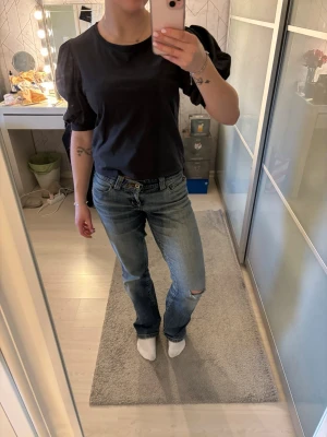 Svart croppad t-shirt med puffärm - Säljer en grå croppad t-shirt med puffiga kortärmar. T-shirten har en enkel rund halsringning och är gjord i ett mjukt bomullstyg. Perfekt för dig som vill ha en basic men ändå trendig look.