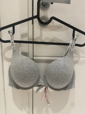 Grå push-up bh från Victoria's Secret - Grå push-up bh från Victoria's Secret med justerbara axelband med logotyp. 💗80C. Använd 1-2 gånger.