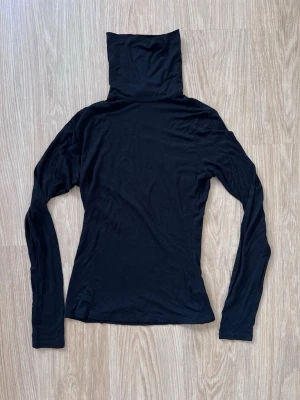 Svart polotopp/turtleneck från H&M, stl S - En svart, långärmad turtleneck, supermjuk!! Enkel utan detaljer eller mönster. Perfekt att styla till jeans eller kjol för en clean look nu i vår!