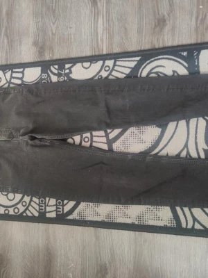 Svarta skinny jeans med hög midja - Säljer ett par svarta skinny jeans med hög midja och klassisk femficksmodell. Jeansen har smal passform hela vägen ner och är tillverkade i ett stretchigt material för extra komfort. Perfekta till en avslappnad streetstyle-look.