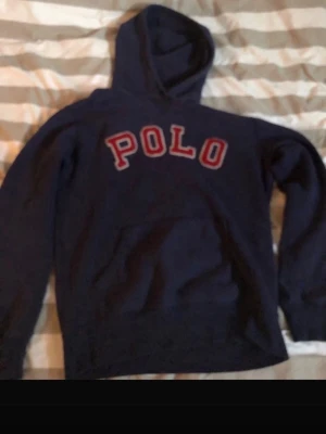 Ralph lauren hoodie - Säljer denna mörkblå Ralph lauren hoodie. En sällsynt hoodie med en snygg röd text på som får den att stå ut lite extra.                                         Storlek S 