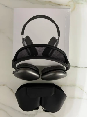 Apple AirPods Max  - Snygga Apple AirPods Max i svart med stilren design. Hörlurarna har en båge i mesh och öronkåpor i aluminium för en premiumkänsla. Perfekta för dig som vill ha grymt ljud och modern look. Levereras med smart skyddsfodral.