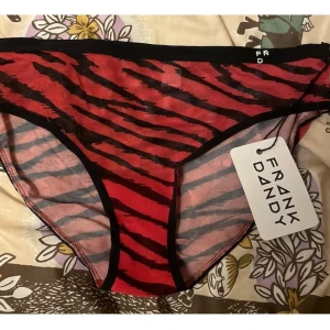 Hiphugger trosa med Zebraprint Frank Dandy - Snygga röda trosor från Frank Dandy med svart zebrainspererat mönster. Klassisk brief-modell med svarta kanter och resår i midjan. Tillverkade i mjukt och stretchigt material för skön passform. Perfekta för dig som gillar djurmönstrat och färgstarkt. 🦓🦓 