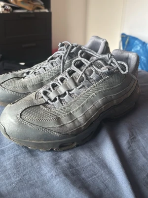 Nike Air Max 95 grå sneakers - Säljer ett par Nike Air Max 95 sneakers i helgrå färg. Perfekta för dig som gillar streetwear och sportig stil.