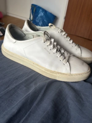 Vita Axel Arigato sneakers - Stilrena vita sneakers från Axel Arigato i läder med diskret logga på sidan. Tillverkade i Portugal och passar perfekt till en clean och modern look.