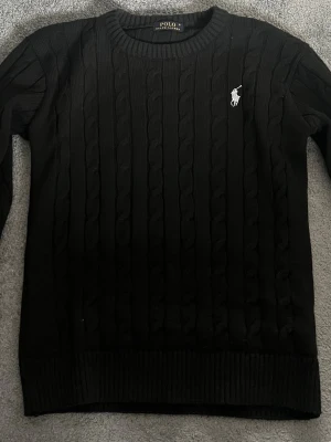 Svart kabelstickad tröja Ralph Lauren - Säljer en kabelstickad svart tröja från Ralph Lauren. Mycket sparmsamt använd, storleken är stor S/M