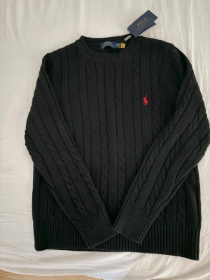 Svart kabelstickad tröja Polo Ralph Lauren - Kabelstickad svart tröja från Polo Ralph Lauren i nyskick, pris kan diskuteras vid snabb affär 