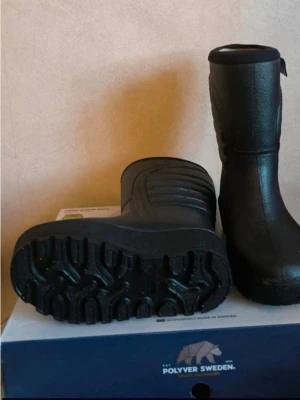 Svarta stövlar från Polyver Sweden - Säljer ett par svarta stövlar från Polyver Sweden. De är tillverkade i slitstarkt syntetmaterial med grov sula för extra grepp. Stövlarna har en hög och rak modell med diskret mönster på skaftet och förstärkta partier framtill.