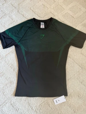 Gymshark Onyx V5 Tröja – Grön - Gymshark Onyx V5 Tröja – Grön 👕 Storlek: L 💚 Färg: Grön ✨ Skick: 10/10 – i nyskick, aldrig eller knappt använd 🧵 Modell: Onyx V5