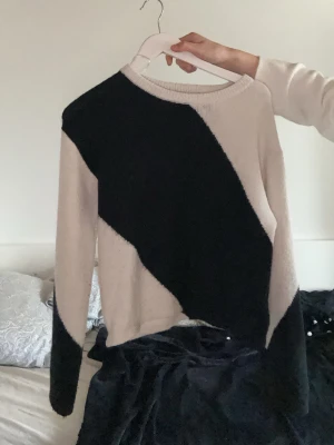 Beige och svart stickad tröja Gina Tricot - Säljer en snygg stickad tröja från Gina Tricot i beige och svart med coolt diagonalt mönster. Tröjan har rund halsringning och långa ärmar. Perfekt för dig som gillar en trendig och bekväm stil.