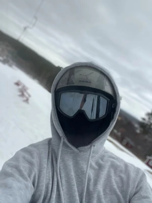 Svarta skidglasögon med spegelglas - Säljer ett par svarta skidglasögon med spegelglas och bred ram. Glasögonen har justerbart band och passar perfekt för skidåkning eller snowboard. Snygg och sportig design som skyddar ögonen mot snö och vind.