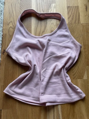 Ljusrosa ribbad linnetopp - Säljer en ljusrosa ribbad linnetopp. Halterneck och mjukt stretchigt material. 