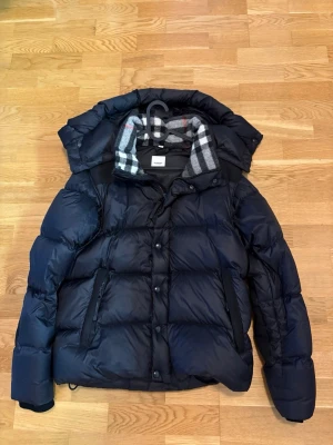 Mörkblå dunjacka/väst  - Snygg svart dun jacka/väst från burberry. Perfekt för vinter men även höst då den går att göra till väst.