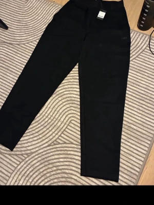 Svarta tapered mjukisbyxor ICIW - Säljer ett par svarta tapered mjukisbyxor från ICIW i storlek S. Byxorna har en avsmalnande passform och är perfekta för en chill och sportig look. Sköna att bära och passar till det mesta. Materialet känns mjukt och flexibelt.