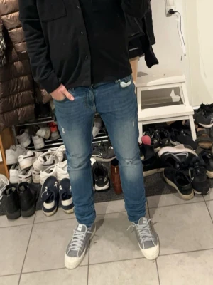 Blå slim fit jeans med slitningar - Säljer ett par blå slim fit jeans med snygga slitningar och tvättade detaljer på låren och knäna (från only & sons). Använda en del men i väldigt bra skick. 