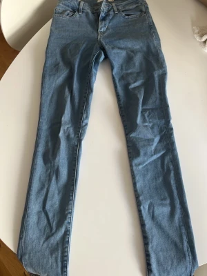 Ljusblå skinny jeans från Levi's - Säljer ett par ljusblå skinny jeans från Levi's med klassisk femficksdesign och dragkedjegylf. Jeansen har en smal passform och är tillverkade i mjukt denimtyg. Perfekta till en avslappnad och trendig look.