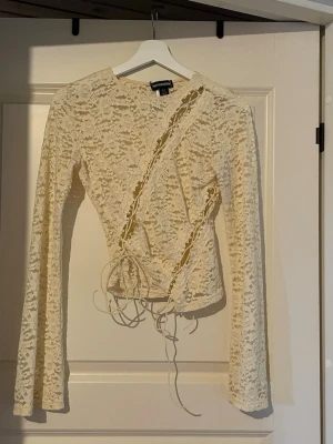 Unik beige spets topp från Prettylittlething  - Beige spets topp från Prettylittlething med unika detaljer, perfekt till fest 💕