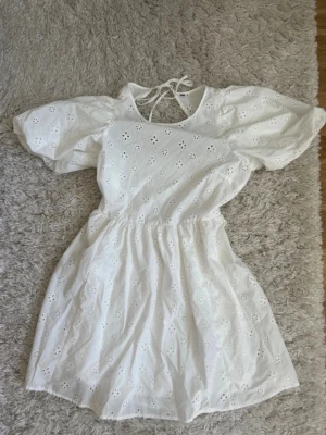 Vit studentklänning med öppen rygg  - Söt vit studentklänning med öppen rygg. Köpt second hand (därav ingen lapp) men kom tyvärr aldrig till användning av mig. Skulle gissa att det är storlek M då den passar mig väldigt bra. 