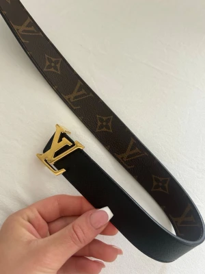Louis Vuitton monogram bälte - Snyggt Louis Vuitton bälte i mörkbrunt skinn med klassiskt monogrammönster och en guldig LV-spänne. Aldrig använt. Storlek 80cm