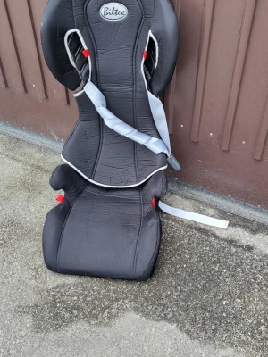 Bilbarnstol från Britax svart - Säljer en svart bilbarnstol från Britax med gråa detaljer och röda fästen. Stolen har hög rygg och sidostöd för extra komfort. Passar perfekt för bilresor och är enkel att montera med bilbälte.