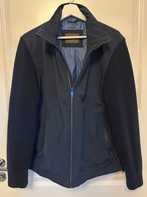 Massimo Dutti Hybridjacka - Hybridjacka i storlek large, tjockt stickade ärmar med foder på insidan. Bra skick förutom att upphängningsöglan är av och att jackan är lite sliten i underkant (syns inte när man har på sig den) se sista 2 bilderna.