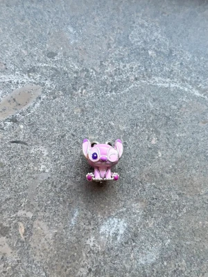 Rosa Stitch-inspirerad pin - Säljer en söt pin i form av en rosa Stitch-liknande figur med stora öron och lila detaljer. Perfekt för ditt Pandora armband.