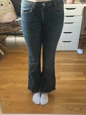 Mörkblå bootcut jeans - Snygga mörkblå bootcut jeans med klassisk femficksdesign och hög midja. Jeansen har en lätt utsvängd passform nertill och är tillverkade i denim med en liten stretch för extra komfort. Perfekta för en avslappnad och trendig look.