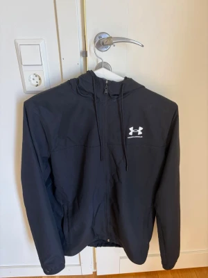 Svart vindjacka från Under Armour - Svart vindjacka från Under Armour. Jackan Är endast använd fåtal gånger  