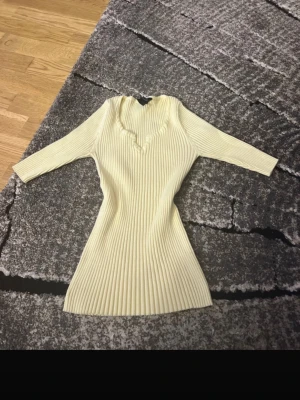 Ribbad cremefärgad tröja Lindex - Säljer en ribbad cremefärgad tröja från Lindex med snygg v-ringning och trekvartsärmar. Tröjan är figurnära och stretchig, perfekt för en stilren look. Materialet är mjukt och bekvämt.