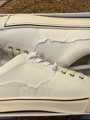 Maison margiela Evolution vita - Snygga vita sneakers med unika råa kanter. Dessa är maison margiela evolution som har blivit riktigt trendiga på senaste. Storlek 45 och är helt nya med box.