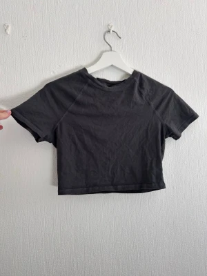 Grå crop top - Grå basic T-shirt crop top. Den är aldrig använd. Ett enkelt plagg att ha till din outfit 