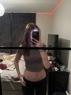 croppad topp med kort ärm - Säljer en croppad  topp med korta ärmar och rund hals. Toppen har en tight passform och är tillverkad i ett mjukt, stretchigt material som sitter snyggt på kroppen. Perfekt till jeans eller kjol för en trendig look.
