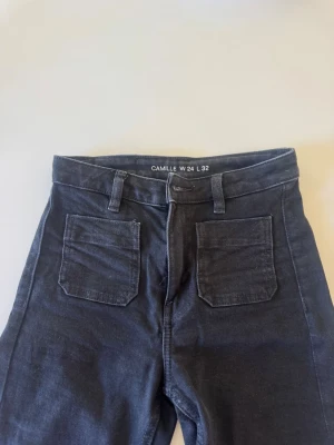 Svarta raka jeans från Bikbok - Snygga svarta jeans från Bikbok (modellen Camille) med raka ben och hög midja. Jeansen har två stora fickor fram och bak samt bälteshällor. Materialet är mjukt och stretchigt för extra komfort. 