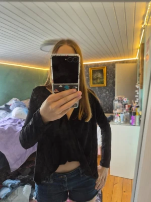 Svart omlottopp från Make Way - Svart omlottopp från Make Way i storlek S. Toppen har lång ärm, croppad passform och djup v-ringning. Perfekt för dig som gillar en stilren och trendig look. Tillverkad i ett mjukt och lätt material.