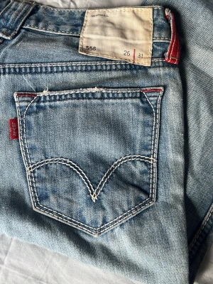 Ljusblå raka jeans - Säljer ett par ljusblå jeans med rak passform och klassisk femficksdesign. Jeansen har en snygg tvätt och subtila slitningar för en avslappnad look. Perfekta till sneakers eller boots och passar till många olika stilar.