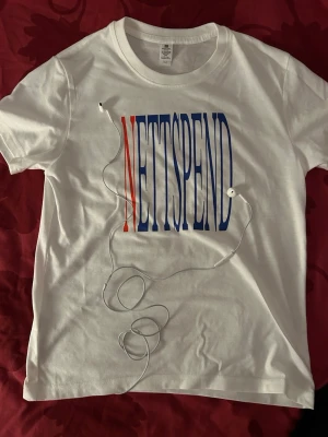 T-shirt - Vit t-shirt med stort tryck på bröstet där det står NETTSPEND, helt ny