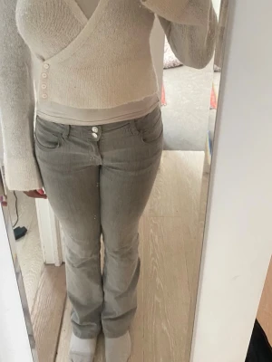  Låg midja det bootcut jeans -  Ljusgrå låg midja. Det bootcut jeans, använt fåtal gånger men har ett litet slitage på ena bakfickan. 