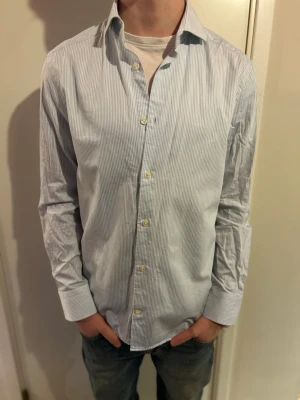 Ljusblå randig skjorta - Klassisk ljusblå skjorta från Riley med tunna vita ränder. Passar perfekt inför vårdagar och kommande sommar!🔥😎