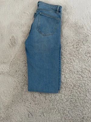 Blå raka jeans från Zara - Säljer soprena blå jeans från Zara i ankel-längd-variant med klassisk femficksdesign och dragked animed knapp. (EU36/US04). Perfekta till sneakers eller boots och har en snygg ljus tvätt. Materialet är bomulls lie stretch för skön passform sopren look.