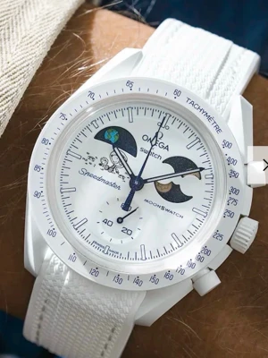 Omega x Swatch vit Speedmaster klocka - Snygg vit Omega x Swatch Speedmaster Moonswatch med coola rymd- och månmotiv på urtavlan. Klockan har vit textilrem och tachymeterbård runt boetten. Perfekt för dig som gillar unika detaljer och stilren design. Finns även band till den vid intresse 