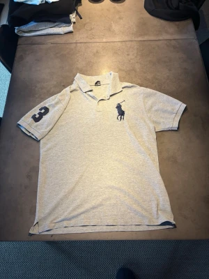 Ralph Lauren Pike - Säljer en riktigt modern, stilig snygg Grå svart pike från Ralph Lauren. Storlek: L. Skriv vid frågor eller kom med bud!