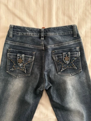 Coola Lågmidjade Bootcut Jeans - Säljer ett par as coola lågmidjade bootcut jeans i storlek 27. Använda fåtal gånger och i super bra skick. Säljer eftersom dem blivit för små💗 Storlek 27, typ 34/36 tycker jag.