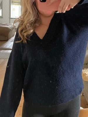 Mörkblå stickad V-ringad Nelly - Mysig mörkblå stickad tröja med V-ringning och långa ärmar. Tröjan har en avslappnad passform och ribbstickade muddar vid ärmslut och nederkant. Den är hyfsat oversize för att vara S. Det är bara att höra av dig vid frågor och tankar💙💙