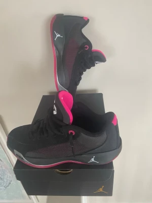 Svarta Jordan sneakers med rosa detaljer, luka 77 - Snygga svarta Jordan sneakers med rosa sula och detaljer. Nästan oanvända, är i riktigt gott skick, nästan nyskick. Storlek 41, riktigt sköna. Nypris är ca 950kr-1000kr. Orginalbox följer med. Skriv för mer info om du har någon fundering.